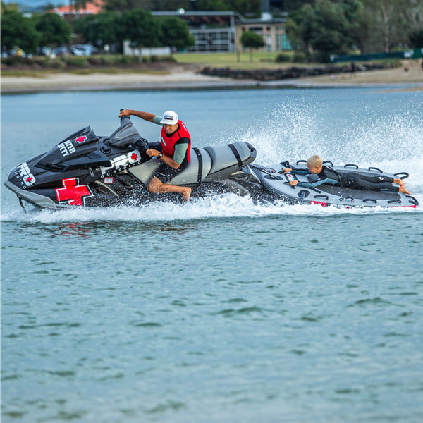 pro guarding jet ski towing boy on a jet ski rescue sled